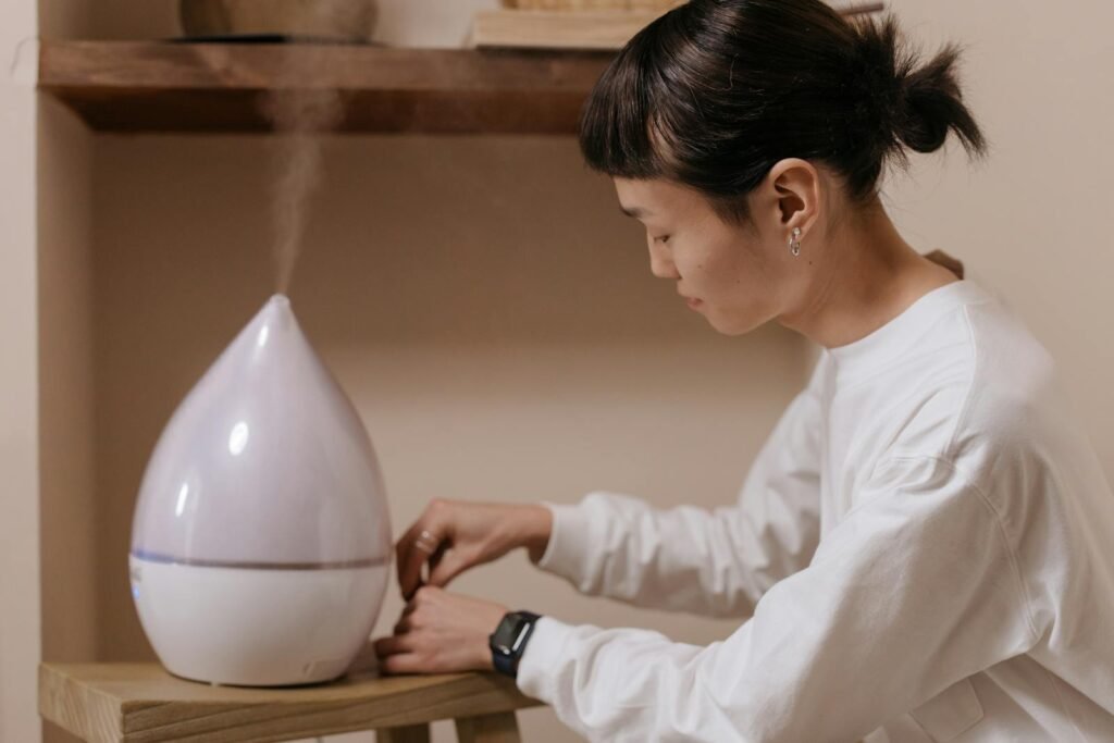 A woman adjusts a humidifier indoors, promoting relaxation and air quality.