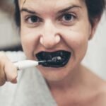 Person brushing teeth with electric toothbrush