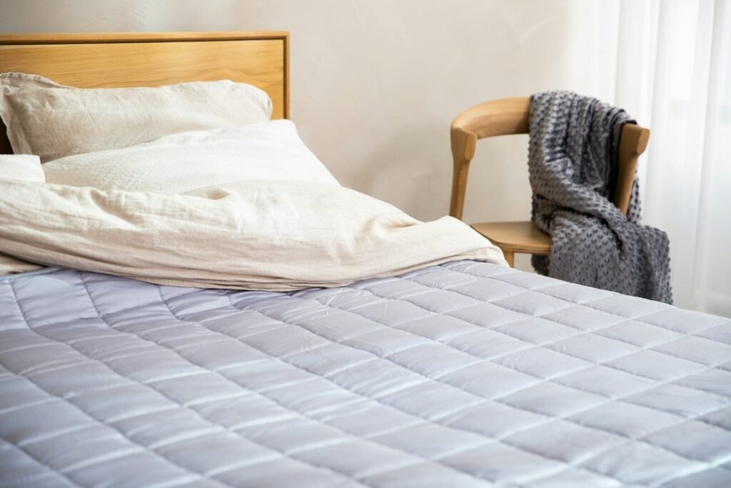 Weighted blanket laid flat on a bed in a cozy bedroom