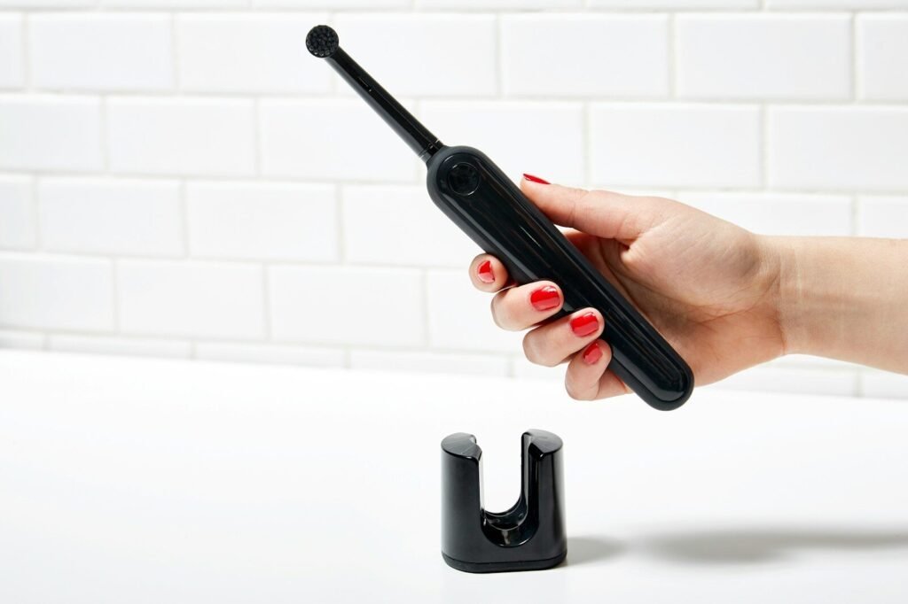 Best Electric Toothbrush Under $50 - Electric toothbrush to be put onto a charging pod in bathroom counter