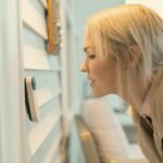 What Smart Home Devices Are Worth Buying? Smart thermostat mounted on wall in modern home