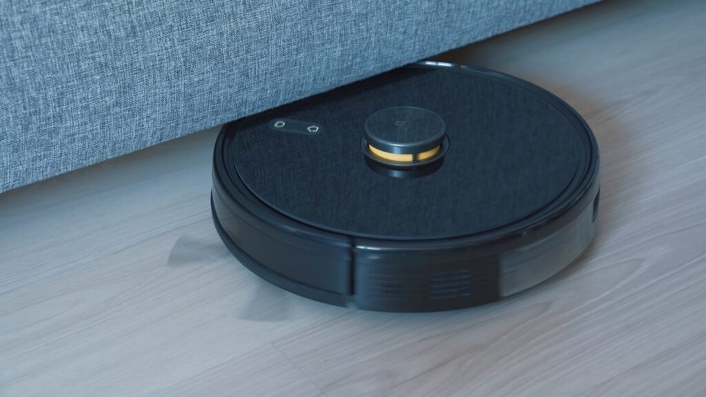 A black robot vacuum cleaning a wooden floor from pet hair