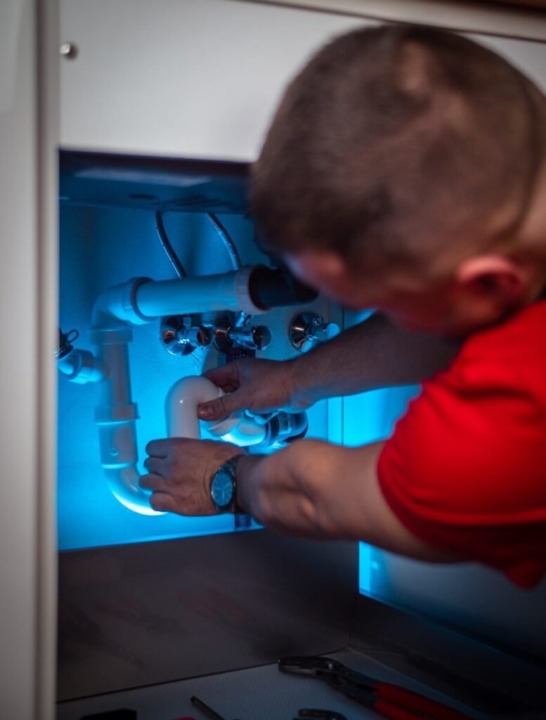 Under-sink cabinet showing water supply pipes and connections